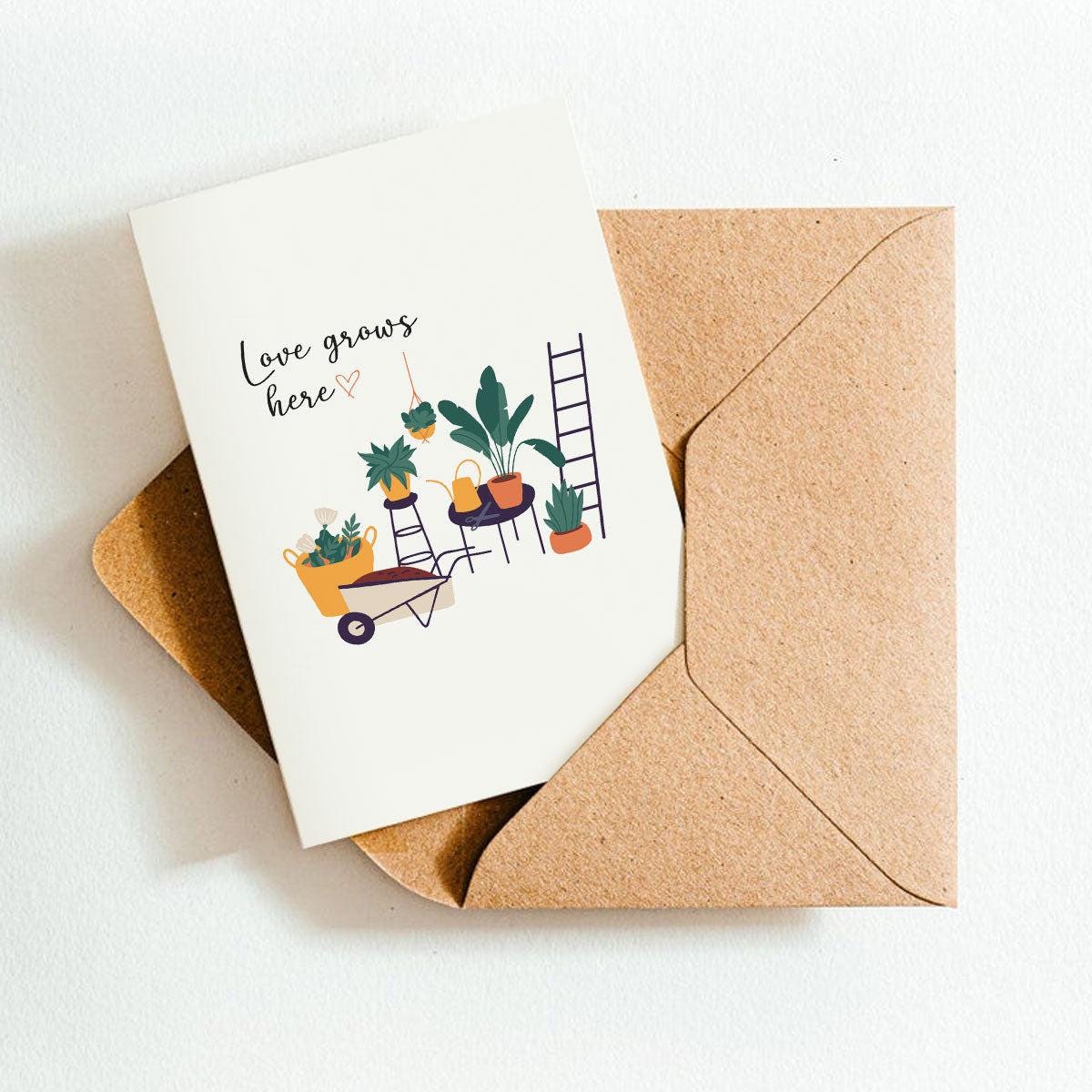 Greeting card with plants and 'Love grows here' text on a brown envelope.