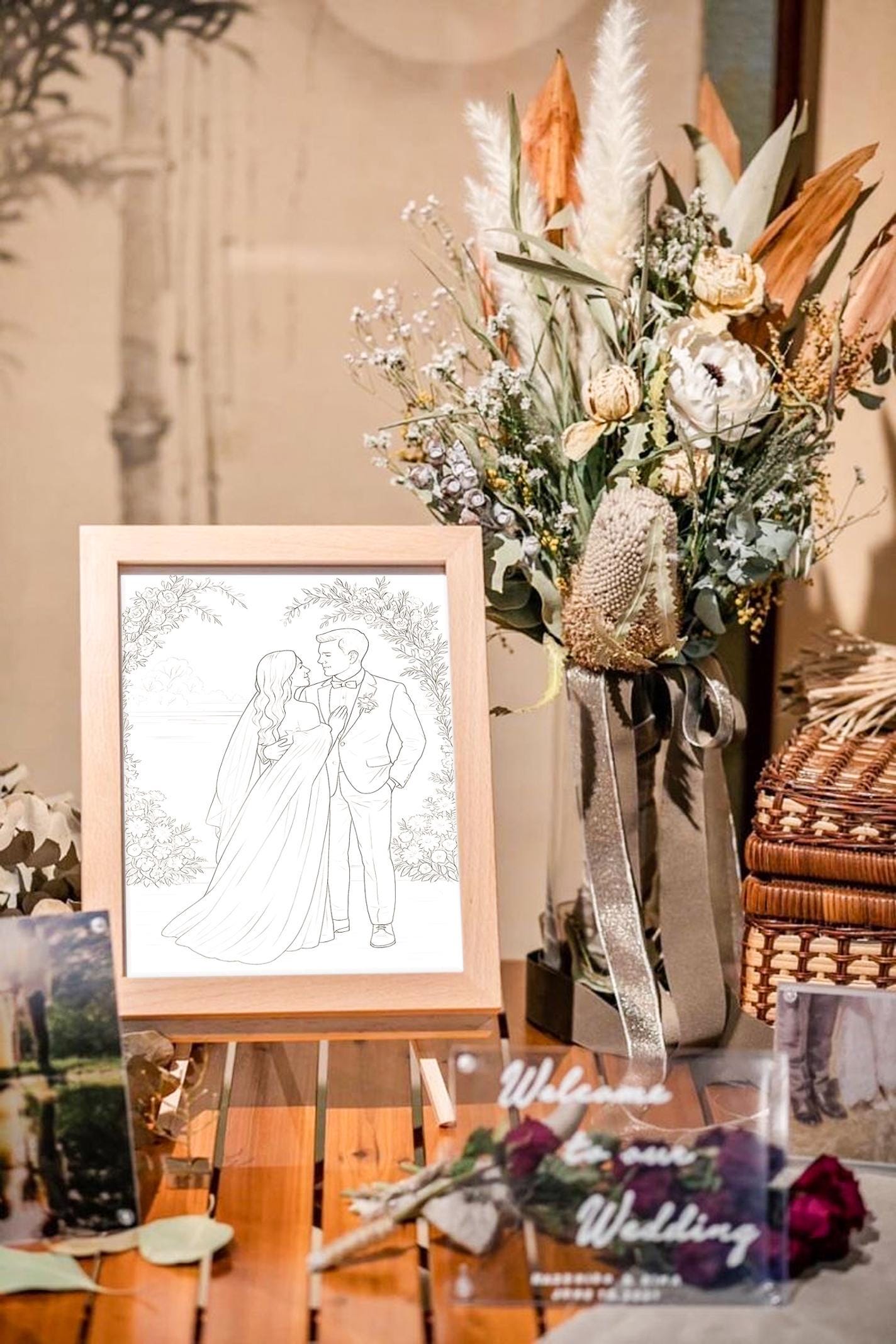 Decorative setup with a bouquet, framed artwork of a couple, and floral arrangements on a table.