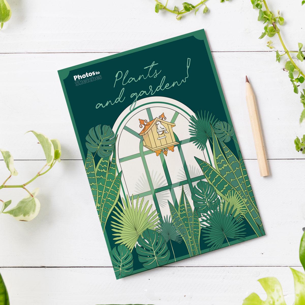 Notebook with a garden-themed cover on a white wooden surface with plants.