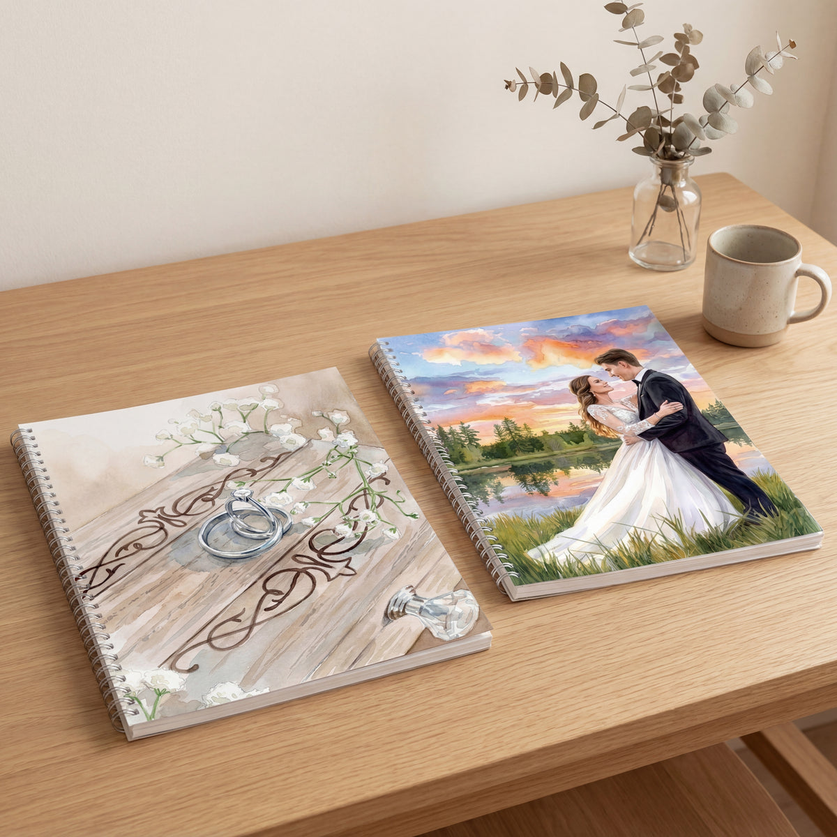 Two wedding albums on a wooden table with a vase and mug in the background.