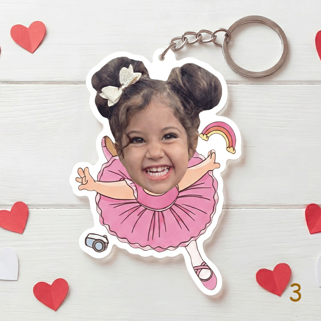 Keychain with a child's face in a pink dress surrounded by heart shapes on a white background