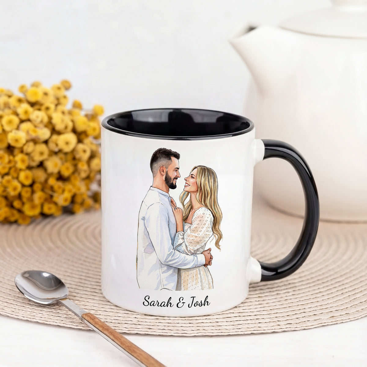 Mug with a printed design of a couple and names 'Sarah & Josh' on a white surface with a teapot and flowers.