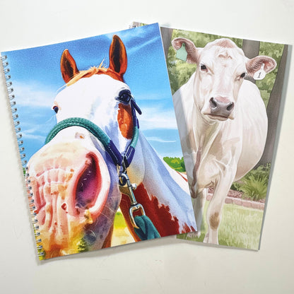 Two coloring books with animal-themed covers featuring a horse and a cow.