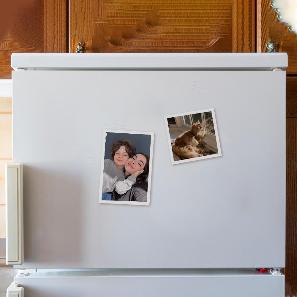 Two personalized photo magnets displayed on a white refrigerator, featuring a family photo and a pet photo.