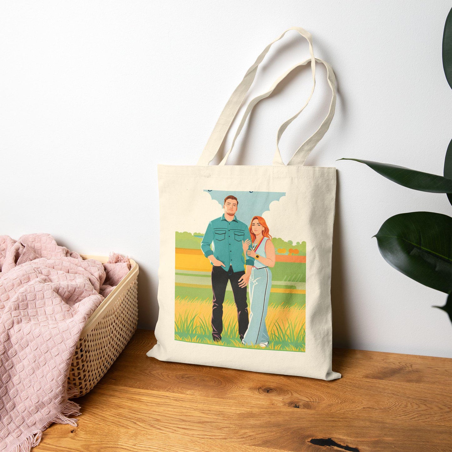 Tote bag with a printed design of two people standing in a field on a wooden surface.