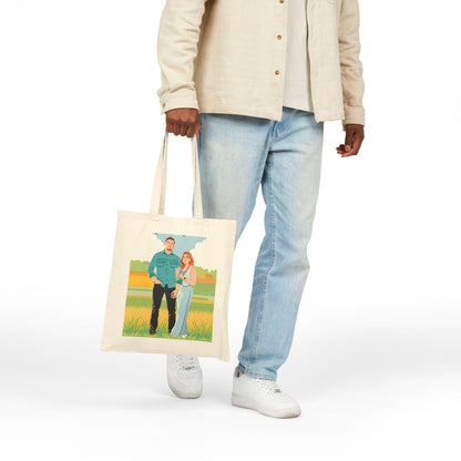 Person holding a tote bag with a printed design of two people on a white background
