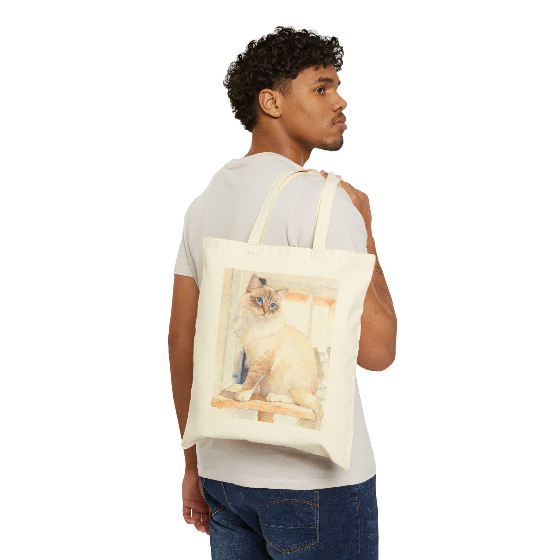 Man carrying a tote bag with a cat design on a white background
