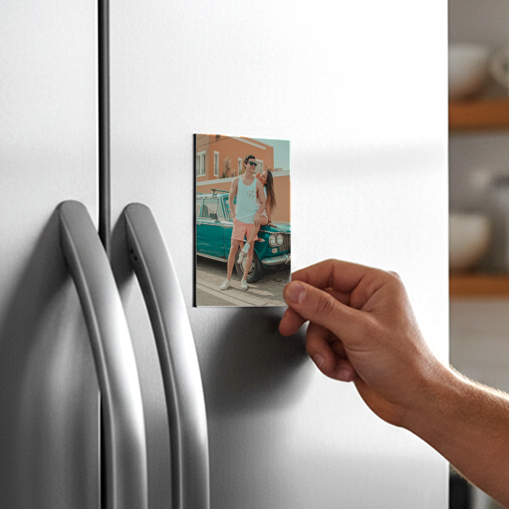 A hand placing a personalized photo magnet on a refrigerator